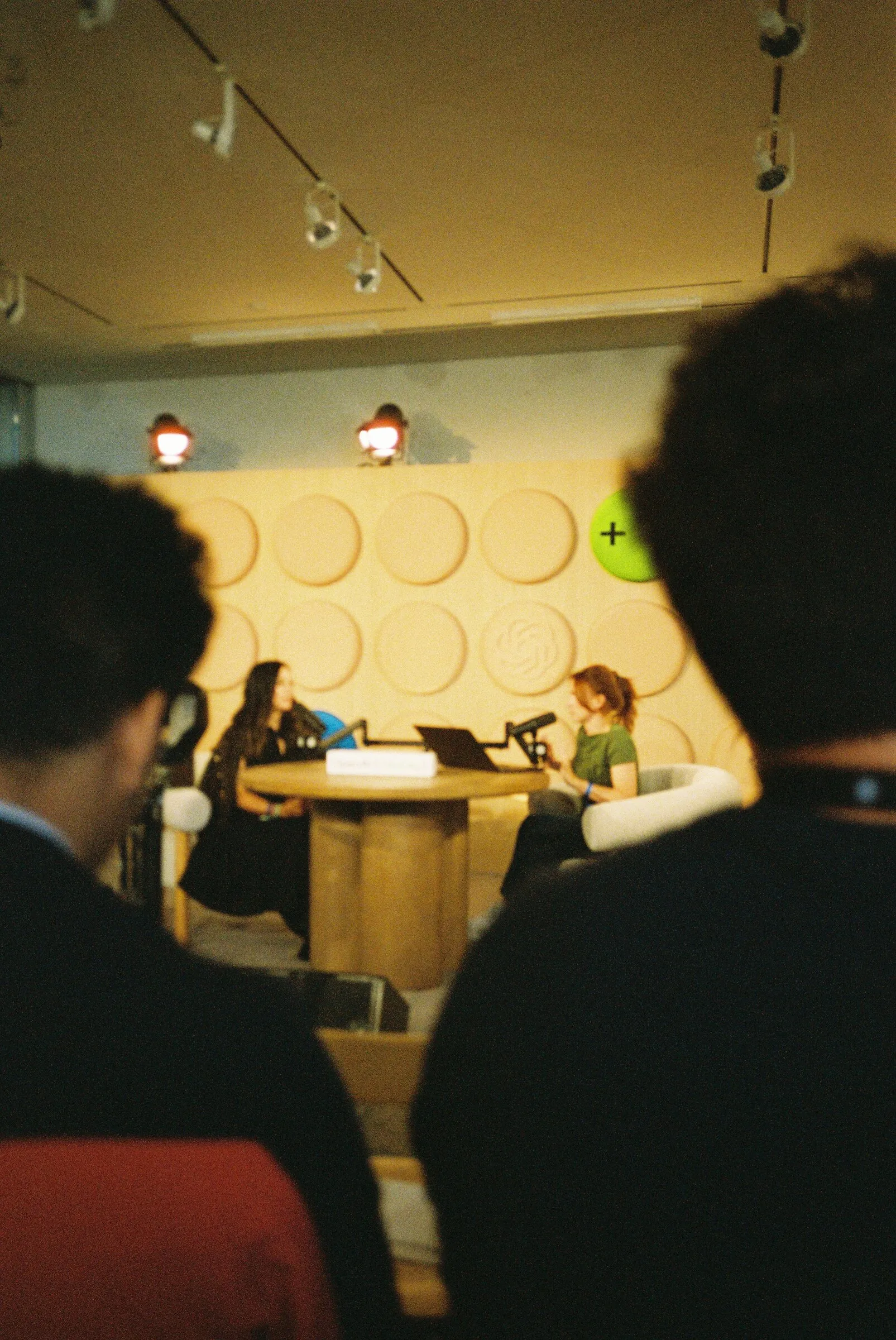 Looking past the backs of people’s heads towards the podcast set