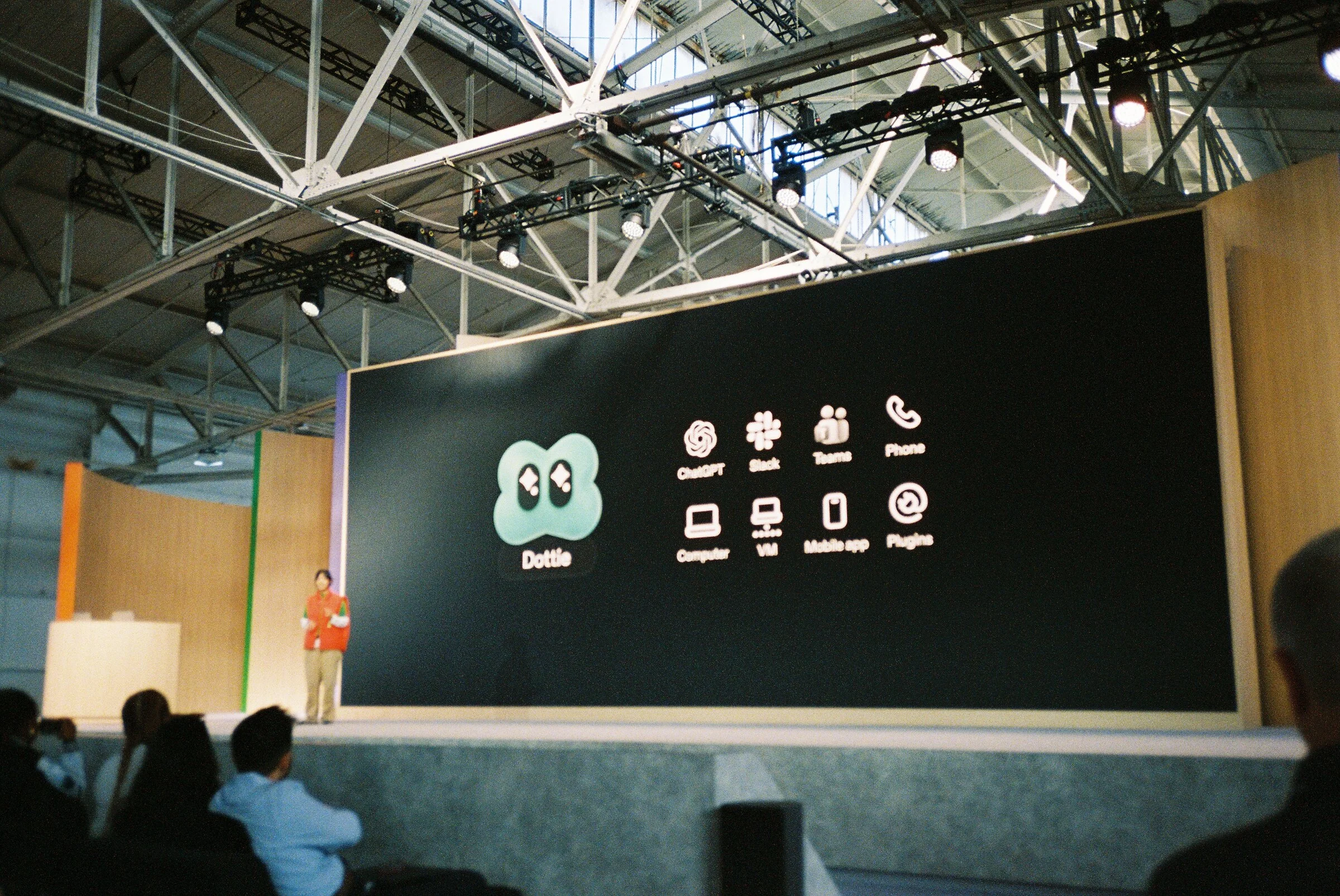 A wide stage showing a slide of app icons, the audience in shadow