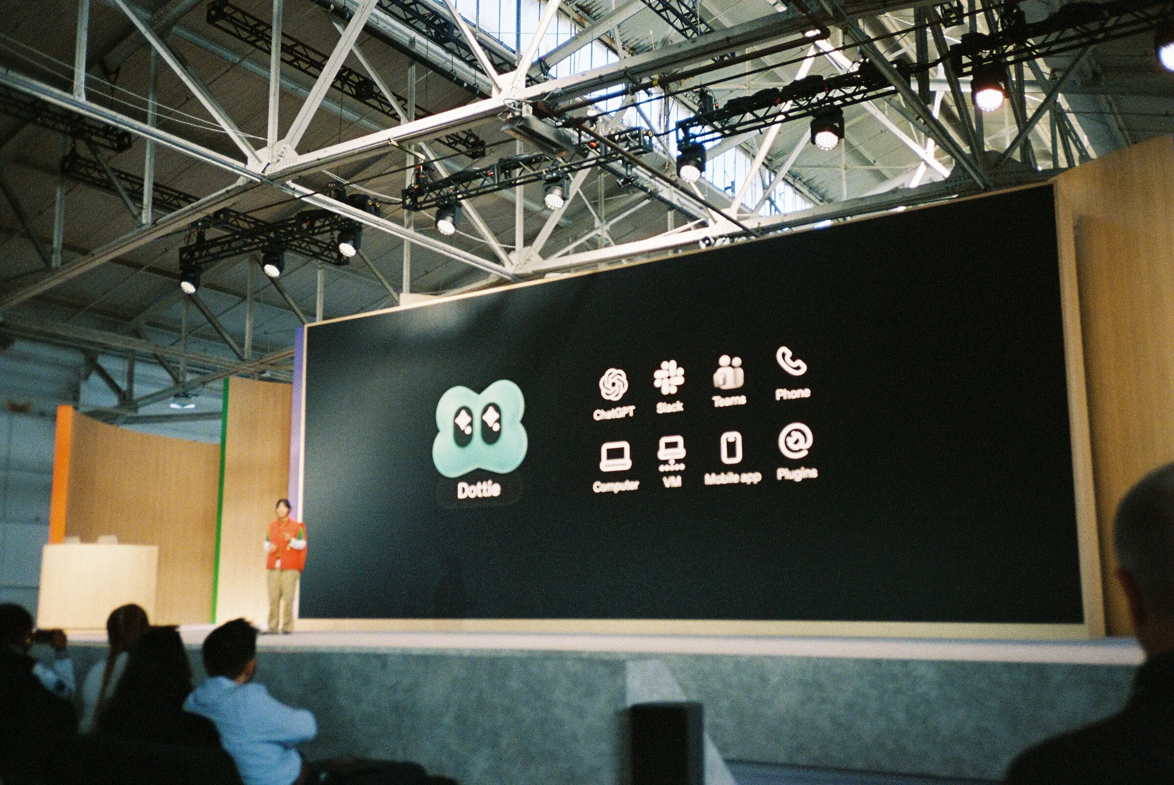 A wide stage showing a slide of app icons, the audience in shadow
