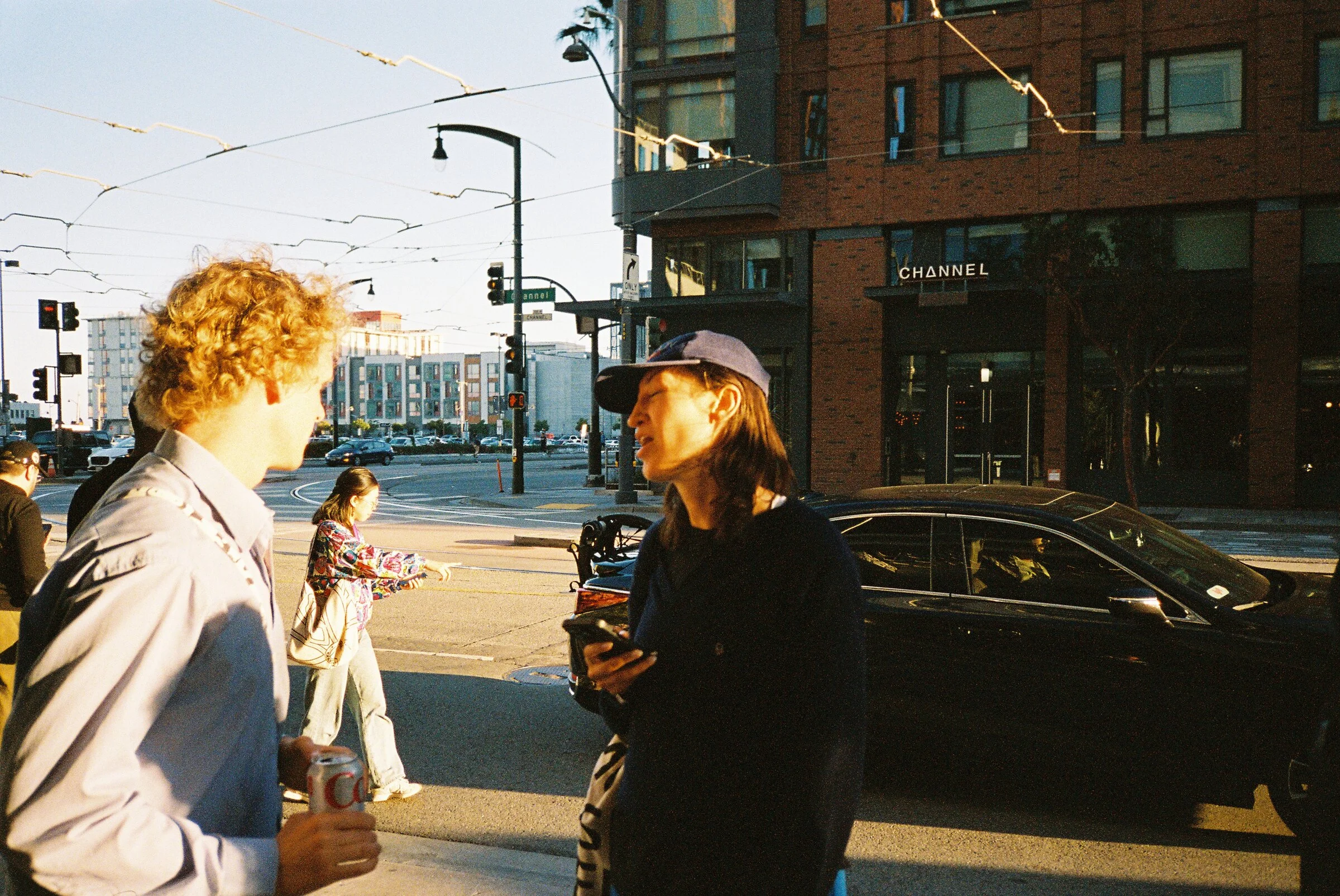 People chatting on a street corner in low evening light