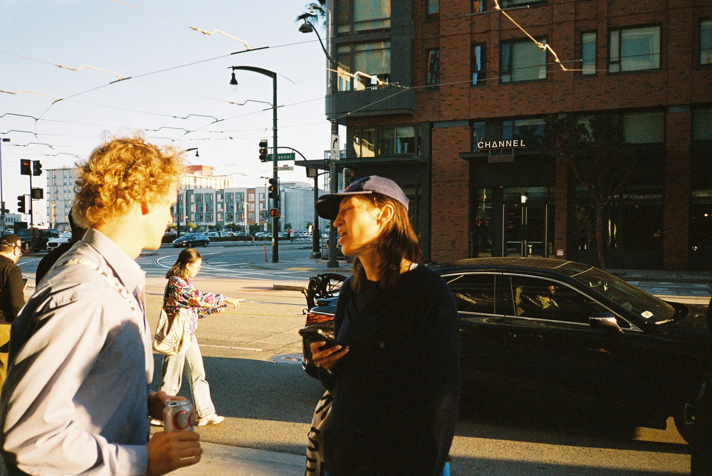 People chatting on a street corner in low evening light