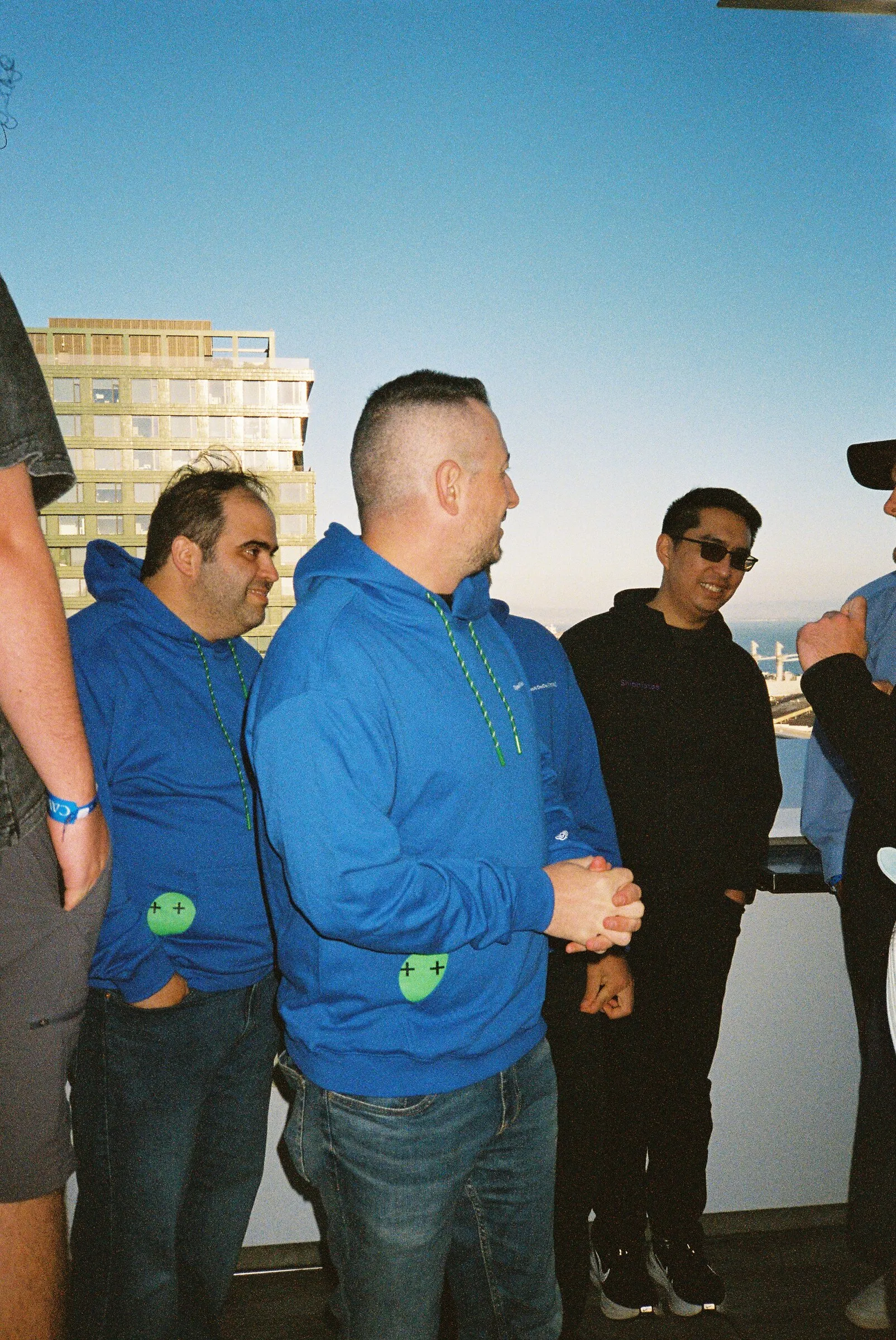 Three men in blue standing on a terrace