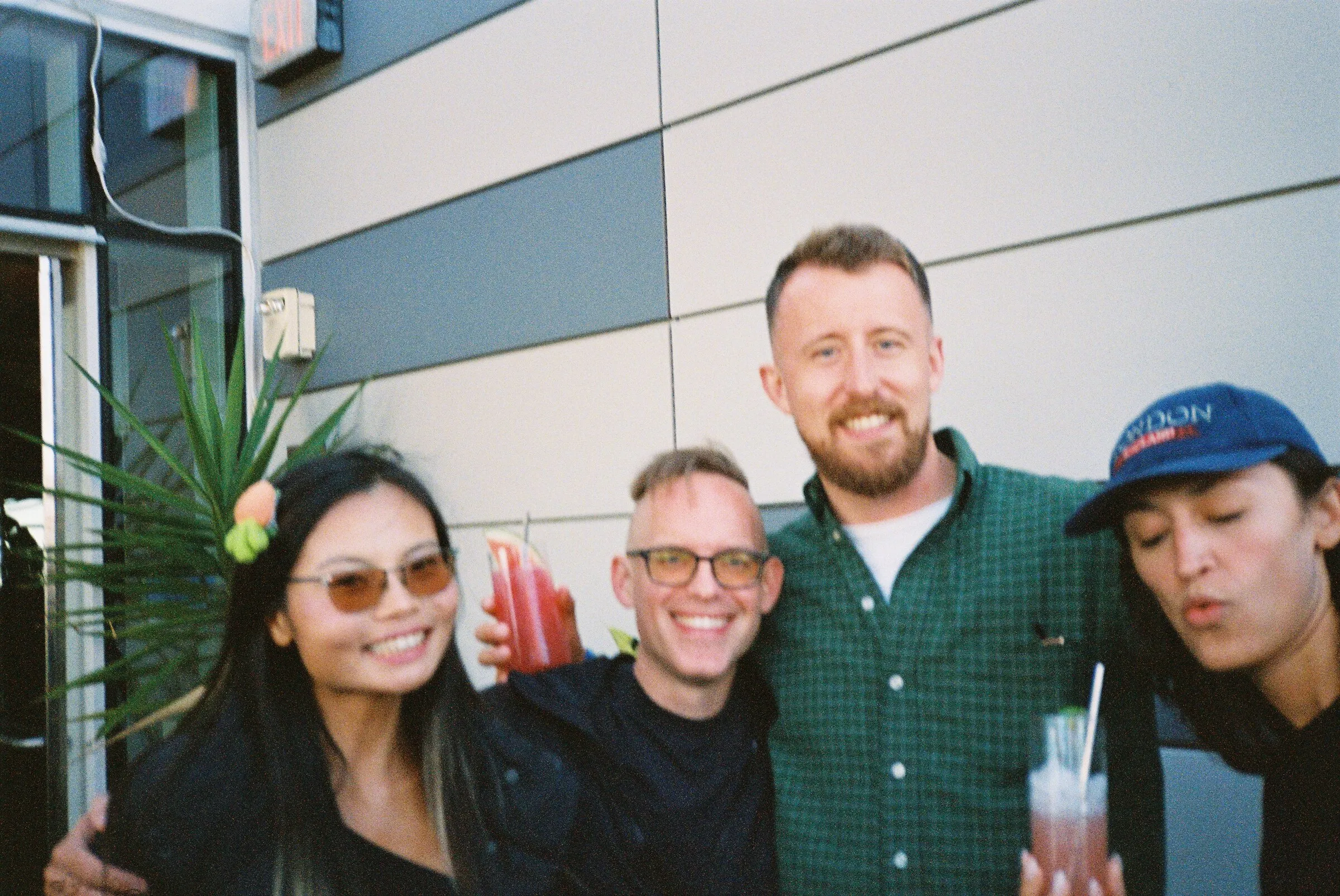 Four friends posing on a terrace in front of a panelled wall