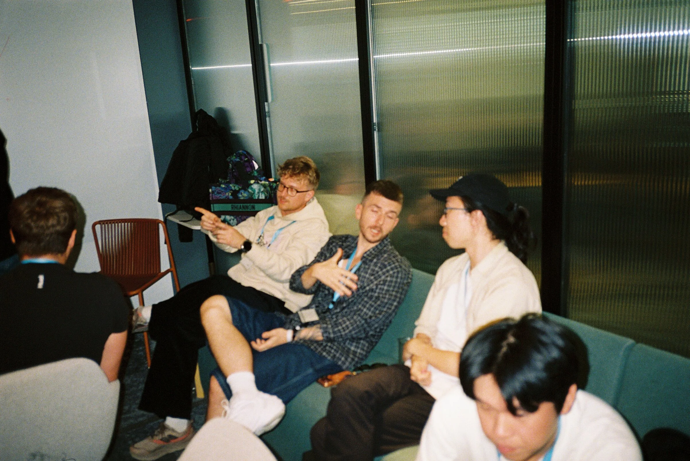 People around a long table with laptops in a warmly lit room